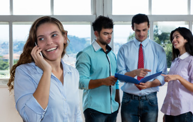 Businesswoman talking at phone with colleagues