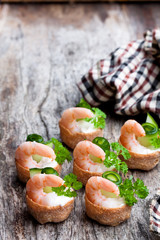 Salted croustades crispy pastry stuffed with cream cheese and prawns on wooden table