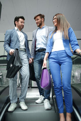 group of business people standing on the escalato