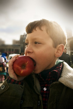 Close-up of a boy biting an apple.