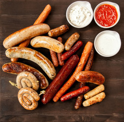 Assorted fried sausages on a wooden board