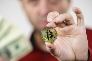 Man having bitcoin coin and cash
