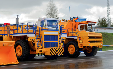 View of the parking lot of an exhibition of large mining trucks. Career