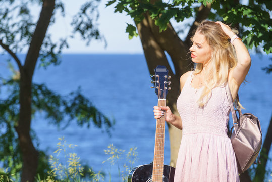 Woman playing acoustic guitar in park