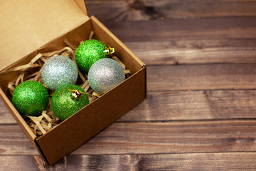 Colorful Christmas balls in a box on a wooden table