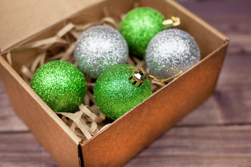 Colorful Christmas balls in a box on a wooden table