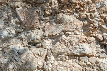 Bright stone wall texture background closeup, fragment from fort in Alanya, Turkey