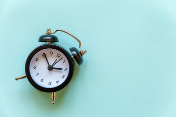 Ringing twin bell vintage classic alarm clock Isolated on blue pastel colourful trendy background....