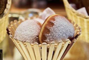 Fresh baked rolls with jam in a wooden basket. Easter buns pastries breakfast food, close-up
