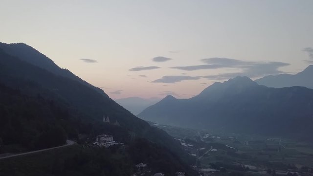 Aerial view of Levico Terme, Italy during sunrise with drone flying forward