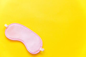 Sleeping eye mask, isolated on yellow colourful trendy background. Do not disturb me, let me sleep. Rest, good night, insomnia, relaxation, tired, travel concept
