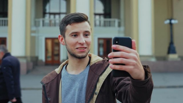Attractive male tourist have video cahtting on smartphone.
