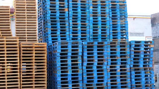 Stack of industrial wood pallets outside a factory