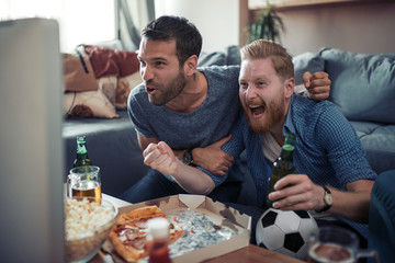 Friends enjoy the football game on TV
