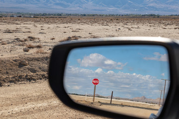 Looking at a Stop Sign in the rear view mirror of a car