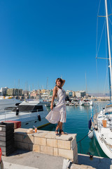 Elegant young tourist visitor woman walking on a sightseeing tour at Heraklion Venetian port, Crete, Greece 