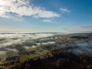 drone image. aerial view of rural area with fields and forests covered in mist