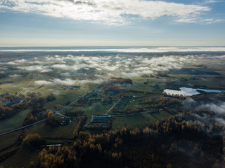 drone image. aerial view of rural area with fields and forests covered in mist