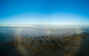 drone image. aerial view of rural area with sun halo above mist