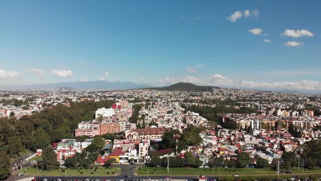Aerial panoramic view in Mexico City, with views of Cerro de la Estrella on a very clear day with blue sky. Drone flying sideways
