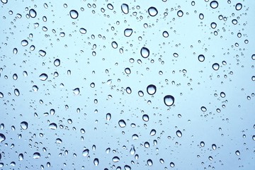 Fototapeta na wymiar CLOSE UP IMAGE OF RAIN DROPS ON GLASS WINDOW