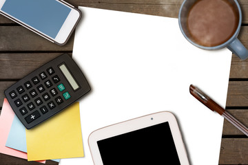 BLANK WHITE PAPERS, A CUP OF COFFEE, SMARTPHONE, TABLET, CALCULATOR,  PAPER NOTES, AND A PEN ON WOODEN TABLE. WORK SPACE