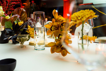 candles on a table next to flowers in a restaurant on a served table,