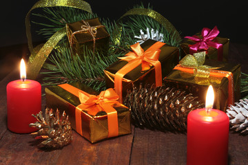 Christmas gift gold, red box with gold color bow and candles. Christmas decoration.