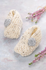 Knitting baby booties on soft background. Hand-made socks for the baby.
