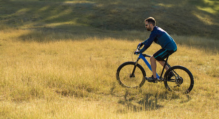 Cyclist in shorts and jersey on a modern carbon hardtail bike with an air suspension fork