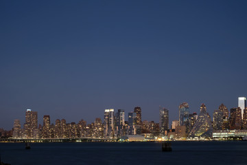 Obraz premium SKYSCRAPERS IN NEW YORK / MANHATTAN WITH SUNSET LIGHT OVER HUDSON RIVER