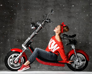 Fototapeta na wymiar Woman ride new electric car motorcycle bicycle scooter present in red blouse under snow