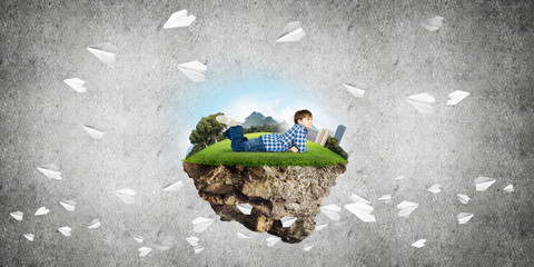 Cute boy of school age lying on grass and smiling to this great world