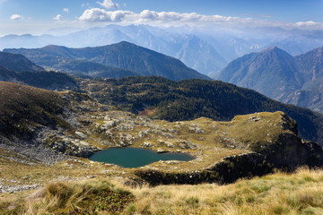 Autumn hiking in Aosta valley, Gressoney, Italy. View of alpine lake of Montagnit from Point Sella near the Coda mountain refuge.