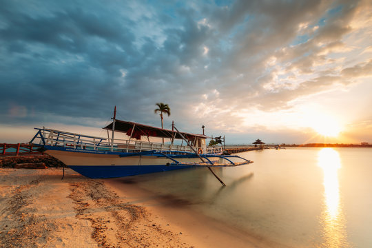 Boat on the beach shore of a white sand beach in the Philippines