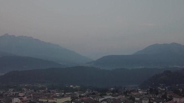 Aerial view of Levico Terme, Italy during sunrise with drone flying forward