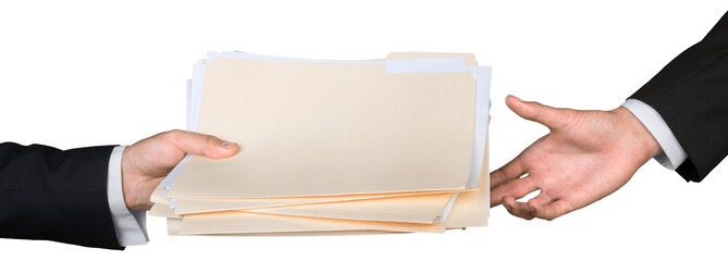 Closeup of Businesspeople Handing File Folders
