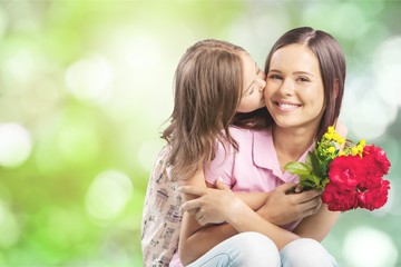 Young woman with little girl and beautiful flowers outdoors