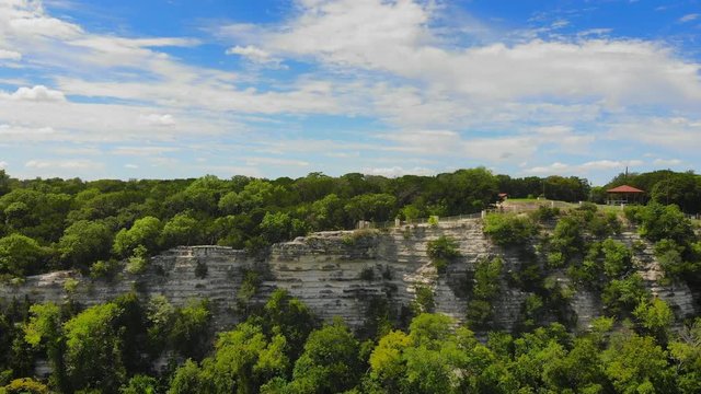 Aerial flight in Cameron Park East in Waco Texas in USA, wide shot moving forwards cliffs and river