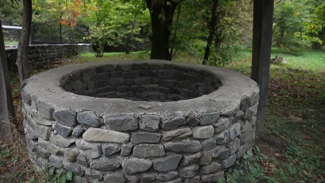 Abandoned well in the forest. Waiting for a terrible girl with a long hair. Halloween concept. Slider shot