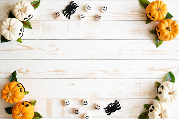 Top view of white and yellow ghost pumpkins with bat spider mummy jelly worm and gift box on white...