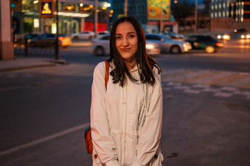 Funny girl standing in the night streets in front of city lights