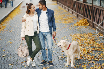 couple walking their dog on a sunny autumn day
