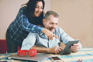 Portrait of couple using laptop at home