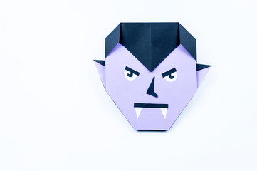 Origami Halloween. Vampire with purple skin and fangs made of paper