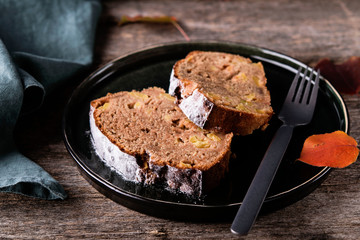 Slices of homemade Apple Cinnamon Coffee Cake on a plate with orange autumn leaves on old rustic wooden table. Selective focus