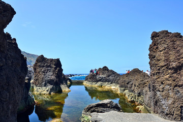 Fototapeta na wymiar Rocky shore and natural lava-rock pool, Porto Moniz, Madeira island, Portugal