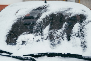 car covered with snow on outdoors parking in winter day