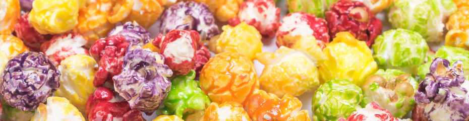 popcorn in colored caramel glaze, close-up background, long photo - obrazy, fototapety, plakaty
