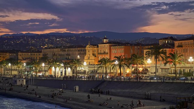Evening shot of street and beach in Nice, France with beautiful cloudy sky after sunset. 4K, UHD